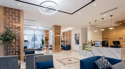 a lobby with blue chairs and a counter at Al Qasr Hotel Al Rabwah in Abha