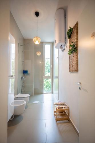 a white bathroom with a toilet and a sink at Enjoy Palasa Comfy Villas in Palasë
