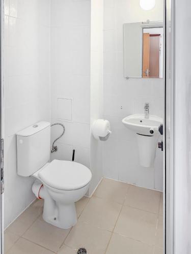 a white bathroom with a toilet and a sink at Solea Family Hotel & Restaurant l Free Parking in Ravda