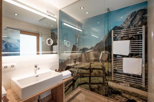 a bathroom with a sink and a mirror at Haus Wildschütz by Hotel Tirolerhof in Tux
