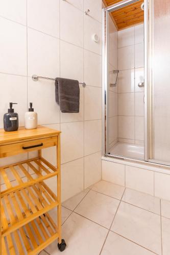 a bathroom with a shower and a wooden table at Wildstein - Ferienwohnungen in Bayrischzell
