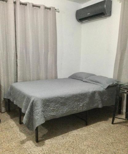 a small bed in a room with a tv at Modern Apartment in Las Piedras in Las Piedras