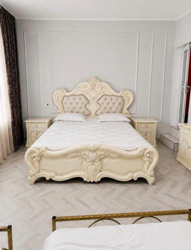 a bedroom with a large white bed with a large headboard at Old Rabati in Akhaltsikhe