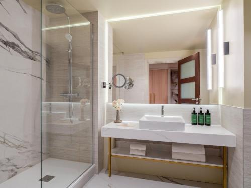 a bathroom with a sink and a shower at Crowne Plaza Paris Marne-la-Vallée in Magny-le-Hongre