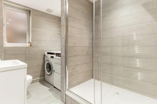 ein Badezimmer mit Dusche und Waschmaschine in der Unterkunft Bright, Spacious Double Room in a Modern Flat in Edmonton