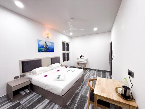 a bedroom with a large bed and a table at Feeali Buddies Inn in Maldive Islands