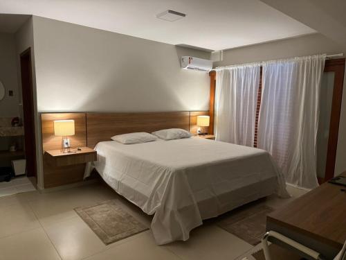 a bedroom with a bed and two tables and two lamps at Charming house in countryside in Brotas