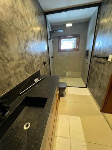 a bathroom with a shower and a black counter top at Charming house in countryside in Brotas