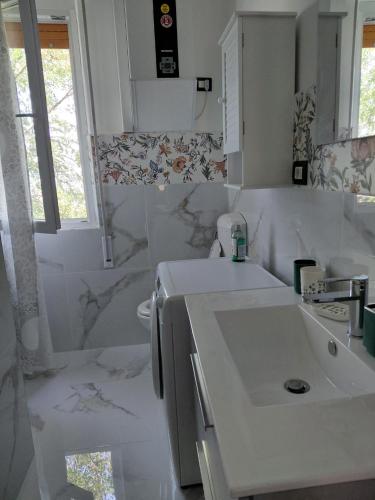 a white bathroom with a sink and a mirror at casa vacanza Lu Murajon in Dogliola
