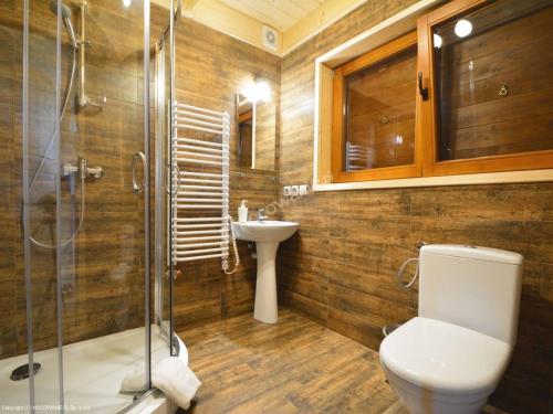 een badkamer met een toilet, een douche en een wastafel bij Domki Czterech Braci in Grywałd