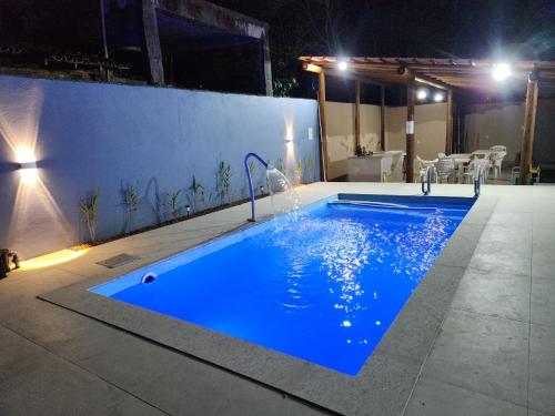 a large blue swimming pool at night at Recanto do mar in Ilhéus