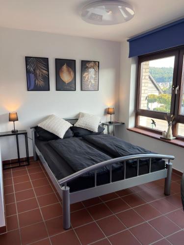a bedroom with a bed in a room with a window at Fernblick Oase in Meschede