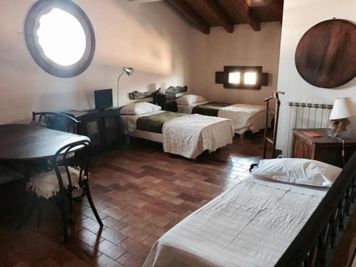 a room with three beds and a table and a window at Fondo Giardinetto in San Cesario sul Panaro