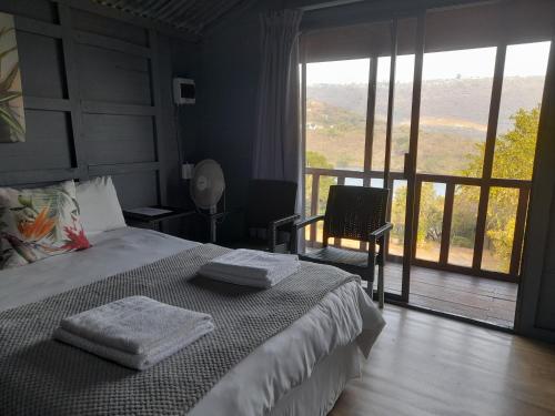 a bedroom with a bed with two towels on it at Entendeni Lodge SelfCatering in Inanda