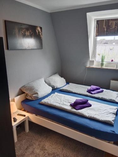 a bedroom with two beds with purple pillows on them at Katharinas Ankerplatz in Flensburg