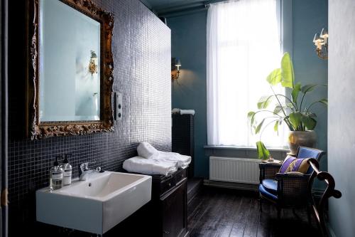 a bathroom with a white sink and a mirror at Guesthouse Nights by Morpheus in Antwerp