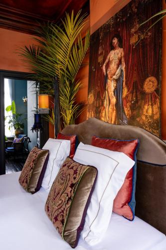 a bedroom with a bed with a painting on the wall at Guesthouse Nights by Morpheus in Antwerp
