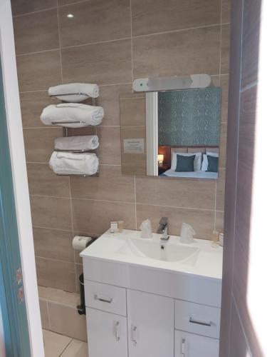 a bathroom with a sink and a mirror and a bed at The Strathearn Hotel in Fife