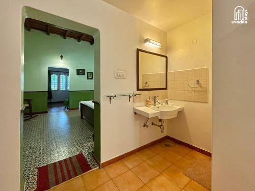 a bathroom with a sink and a mirror at The Thota Mane by evaddo stays in Sakleshpur
