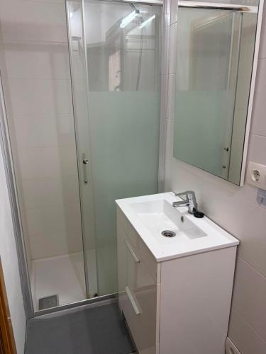 a white bathroom with a shower and a sink at Casita in Castrojeriz