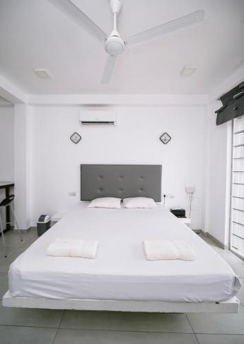 a white bedroom with a large white bed with two pillows at Vega Haven in Matara