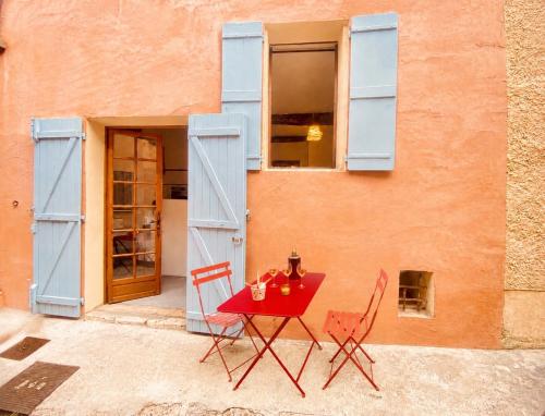 a red table and chairs in front of a building at Cabris Village Escape - Junior Suite in Cabris