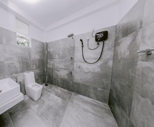 a bathroom with a shower and a toilet and a sink at Vega Haven in Matara