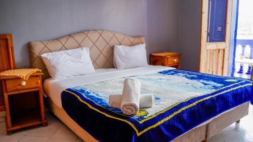 a bedroom with a bed with a towel on it at Le Lagon Bleu Oualidia in Oualidia