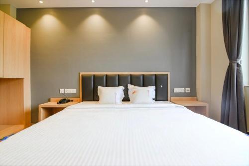 a bedroom with a large white bed with two pillows at J P Guest House in Howrah