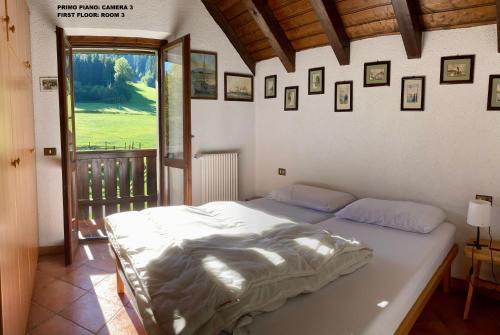 a bed in a bedroom with a view of a golf course at Casa vacanze Ravascletto in Ravascletto