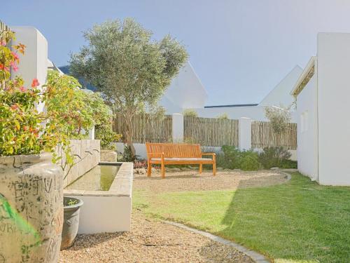 a wooden bench sitting in a yard next to a fence at Fijnbosch Self-Catering Units in Jacobs Bay