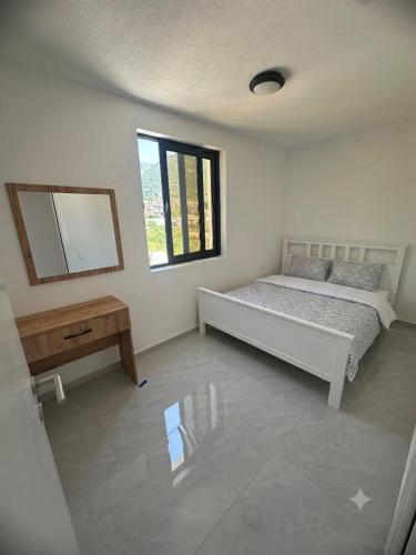 a bedroom with a bed and a mirror and a table at Azur Apartments Bar in Bar