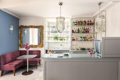 a kitchen with a bar with red chairs and a mirror at Nus Hotel Poerio in Rome