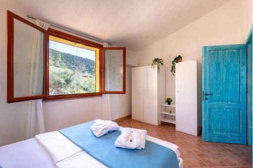 a bedroom with a bed with a blue door and a window at Domu Margarida in Chia