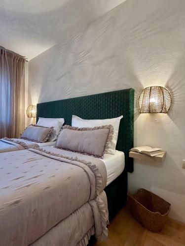 a bedroom with a large bed with a green headboard at Villa Silente in Oklaj