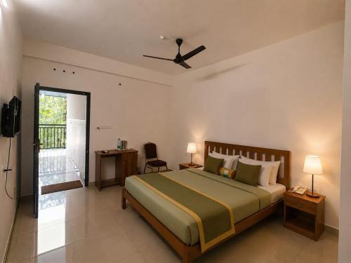 a bedroom with a large bed and a balcony at Uthram Avenue in Tāmarakulam