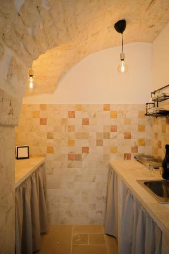 a kitchen with a counter and a sink in a room at Dimora Le Volte Ostuni in Ostuni