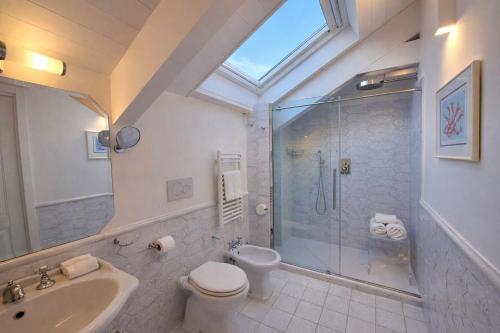 a bathroom with a shower and a toilet and a sink at Odisseo Apartments in Minori