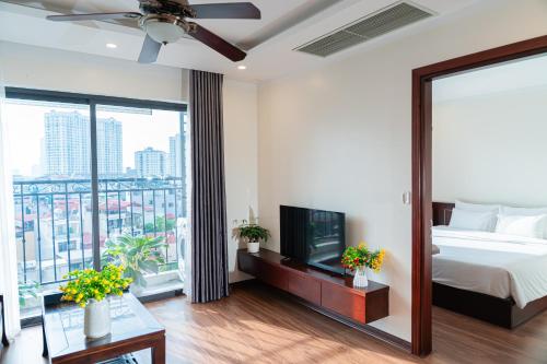 a bedroom with a bed and a tv and a balcony at A89 Hotel & Spa Hanoi in Hanoi