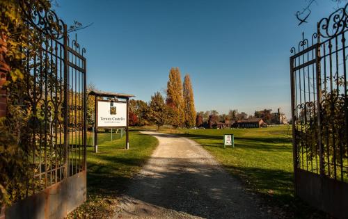 a gate with a sign next to a dirt road at B&B Tenuta Castello Golf Club in Cerrione