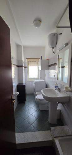 a bathroom with a white toilet and a sink at Civico 22 Guest House in Pellaro