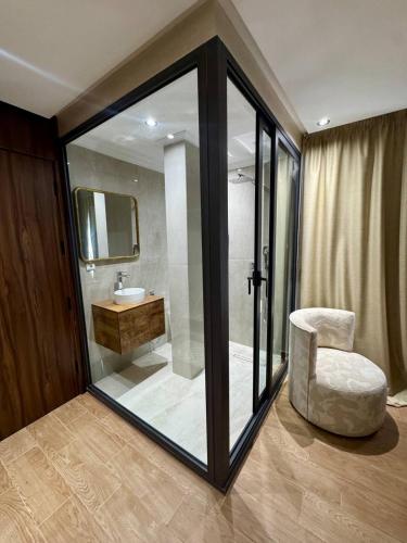 a bathroom with a chair and a sink and a mirror at Royal Room 5 Chambre Royale in Asilah