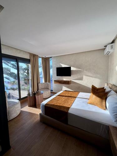 a bedroom with a large bed and a television at Royal Room 5 Chambre Royale in Asilah