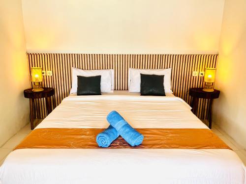 a bed with a pair of blue shoes on it at Pasir Homestay in Gili Gede