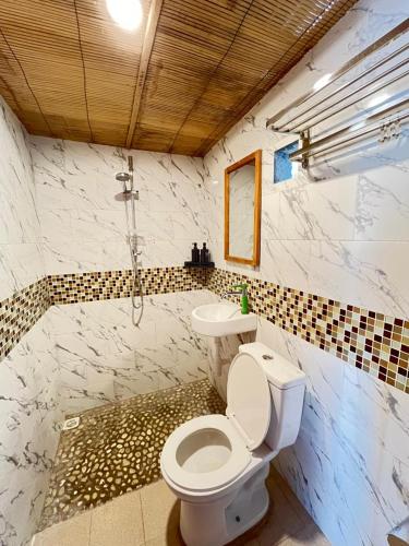 a bathroom with a toilet and a sink at Pasir Homestay in Gili Gede