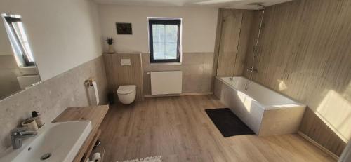 a bathroom with a tub and a sink and a toilet at House by the water in Lesík