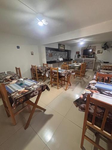 a room with wooden tables and chairs and a television at Hospedaria Monumento in São Paulo