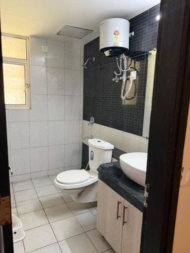 a bathroom with a toilet and a sink at Apartment for rent in Noida