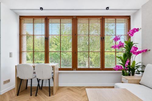 a dining room with a table and chairs in front of a window at Baltic Sand - Apartamenty I Pokoje Władysławowo in Władysławowo