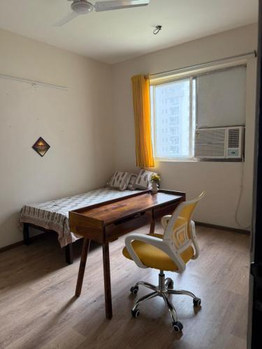 a bedroom with a bed and a desk and a chair at Apartment for rent in Noida